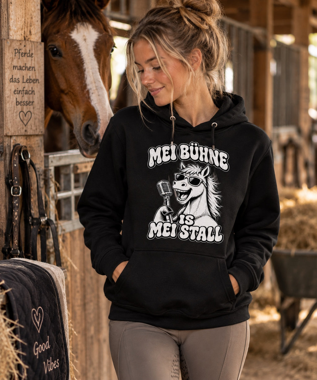 Frauenmodel im schwarzen Pferdemädl Hoodie im Pferdestall