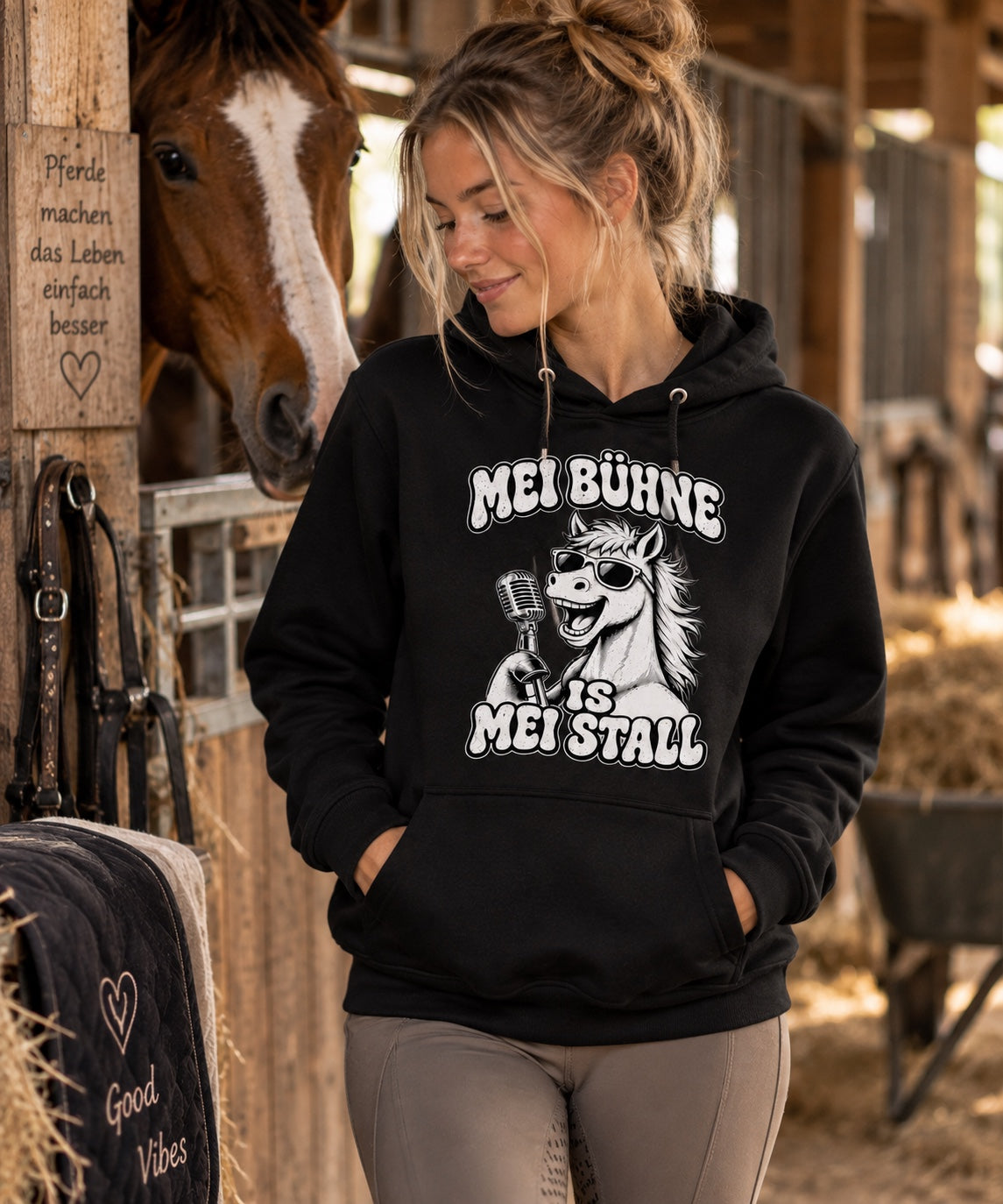 Frauenmodel im schwarzen Pferdemädl Hoodie im Pferdestall
