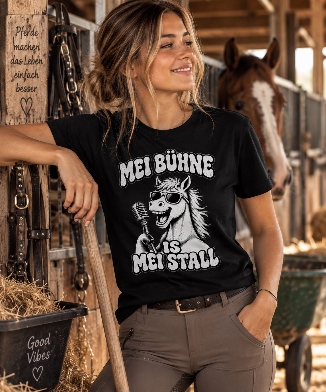 Frauenmodel im schwarzen Pferdemädl Shirt im Pferdestall