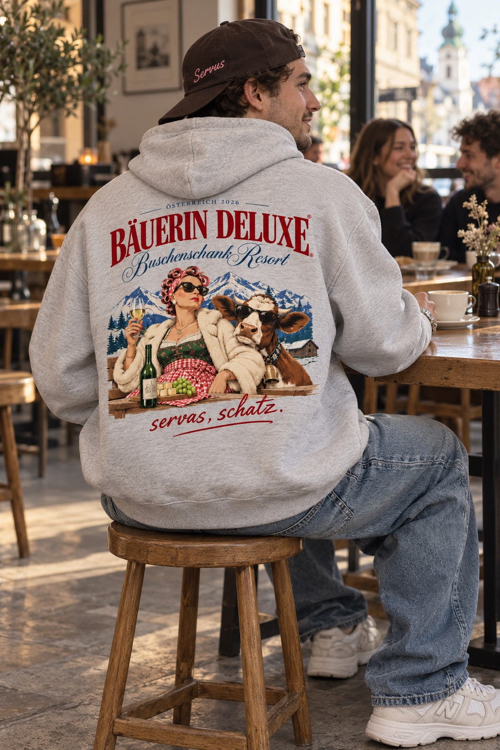 Bäuerin Deluxe Herren Oversize-Hoodie grau meliert – Rückenansicht im Café