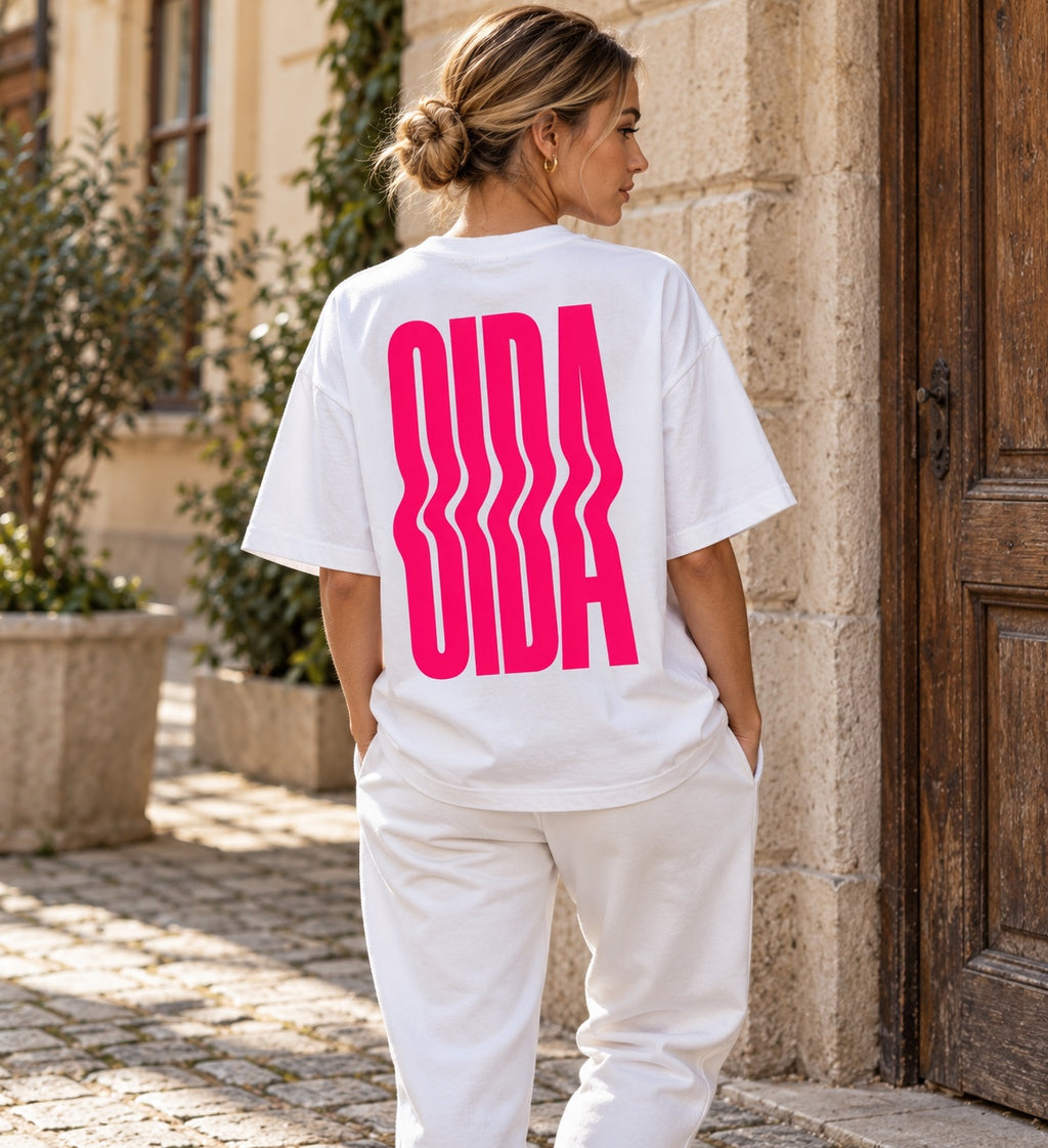 Damenmodel trägt weißes Oversize T-Shirt mit pinkem OIDA Rückenprint
