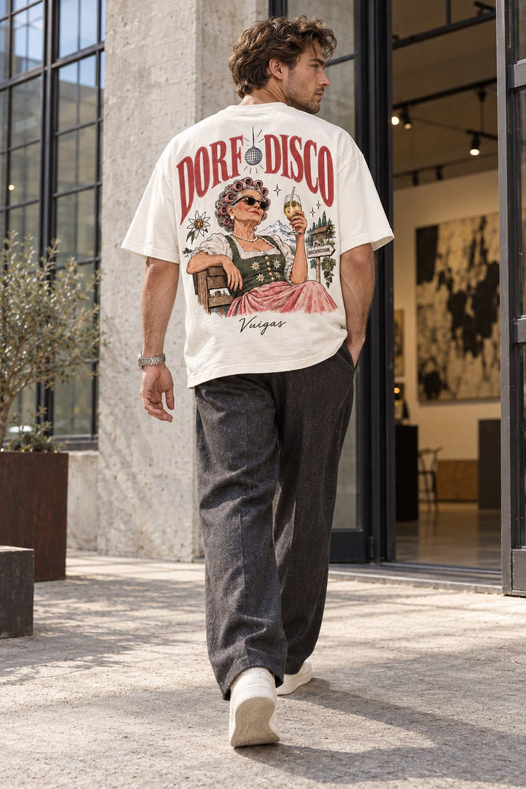 Herren Oversize-T-Shirt Dorf Disco – Vuigas in Weiß am Model mit Stoffhose