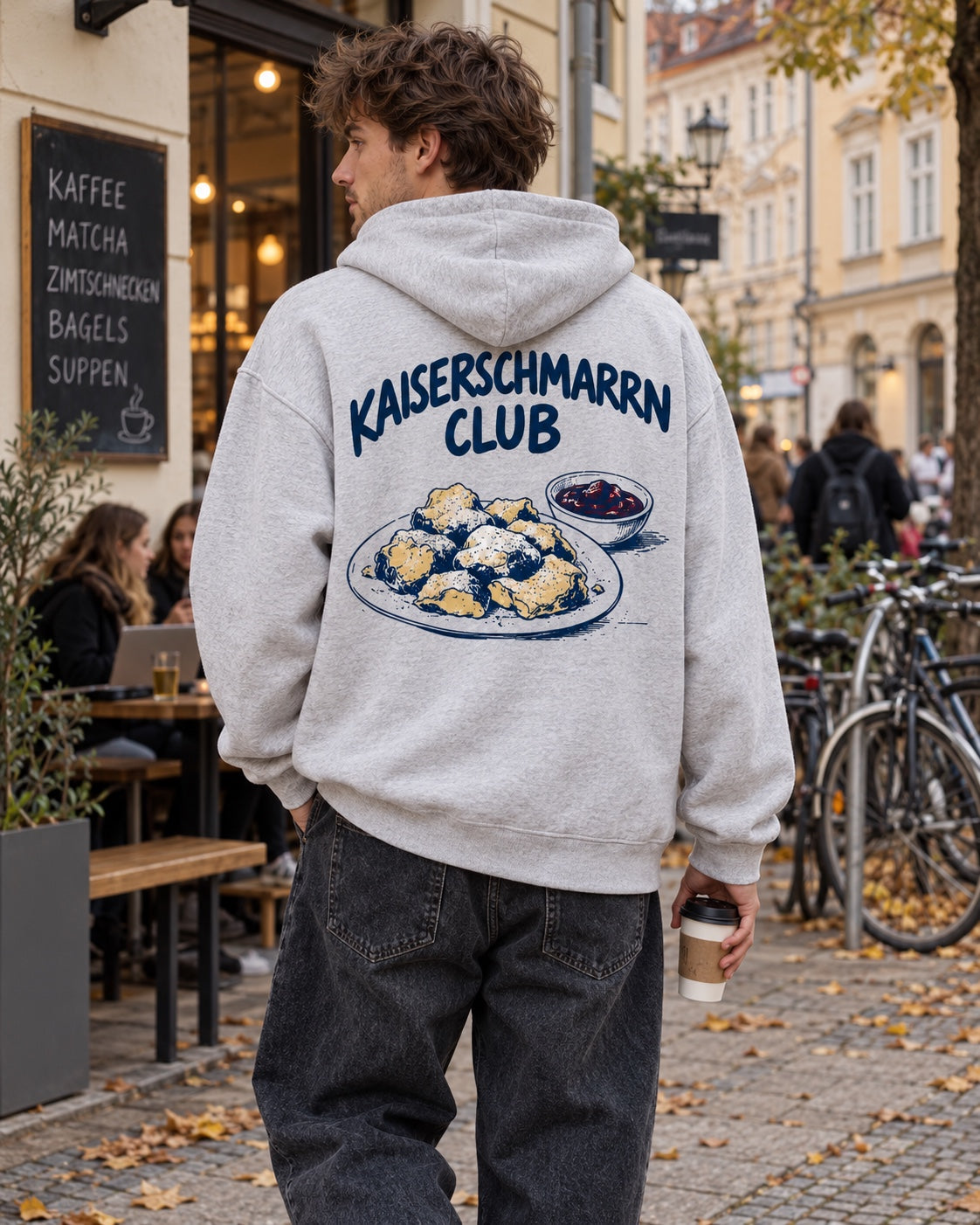 Herrenmodel mit graumeliertem Oversize-Hoodie Kaiserschmarrn Club – Rückenansicht