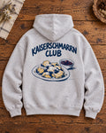 Graumelierter Oversize-Hoodie Kaiserschmarrn Club – Rückenmotiv auf Altholztisch