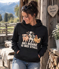 Model mit schwarzem Hoodie Mei Bühne is mei Stall vor alpiner Holzhütte