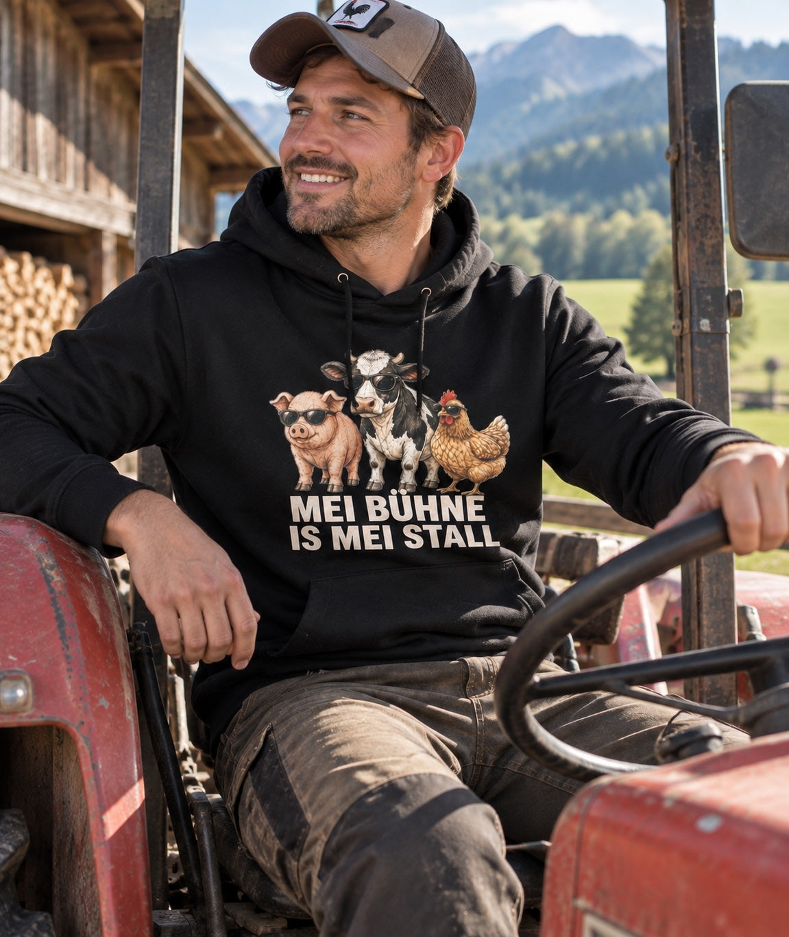 Model trägt schwarzen Herren-Hoodie Mei Bühne is mei Stall am Traktor