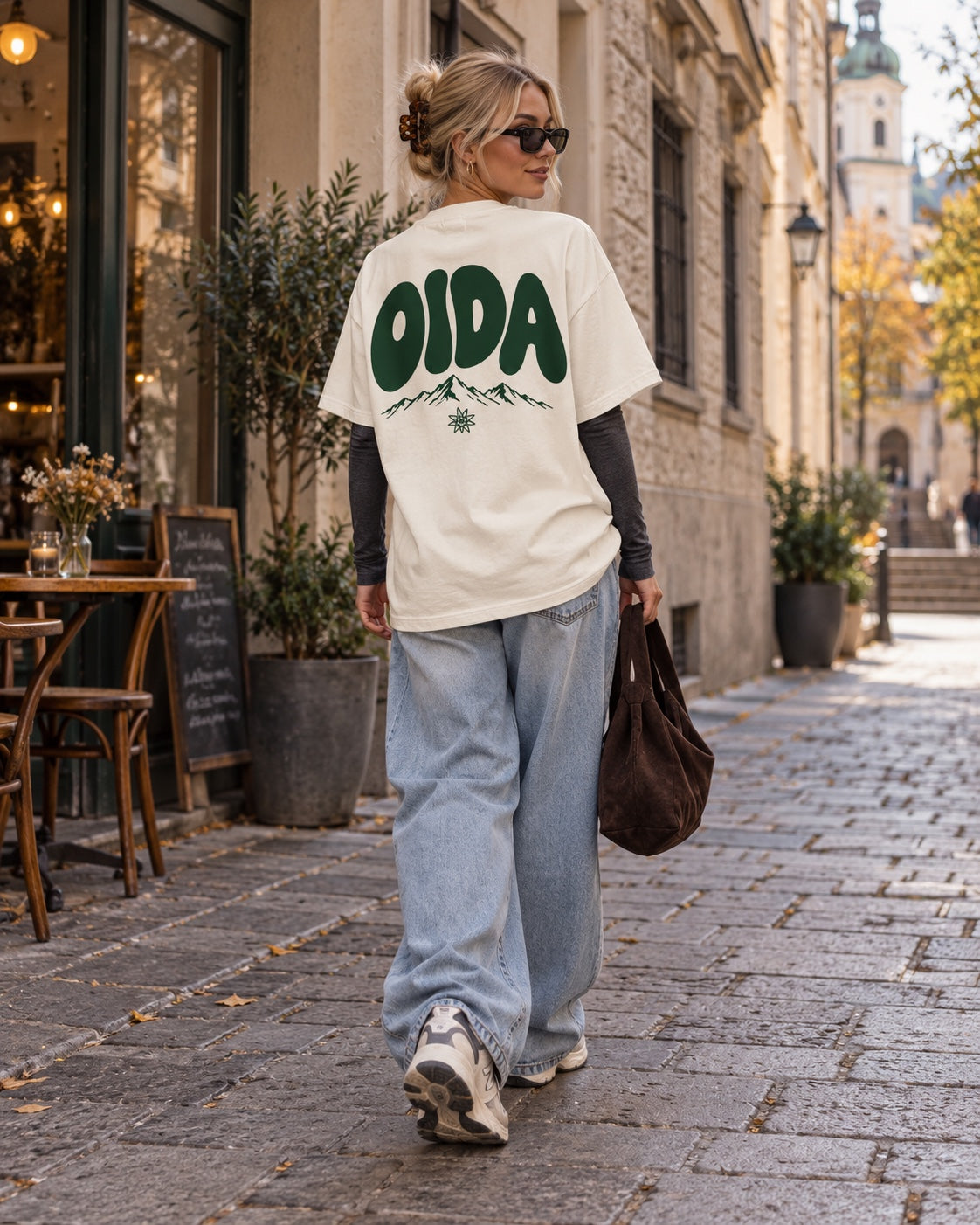 Damen Oversize-T-Shirt OIDA in Weiß – Rückenansicht mit Baggy Jeans und Longsleeve kombiniert