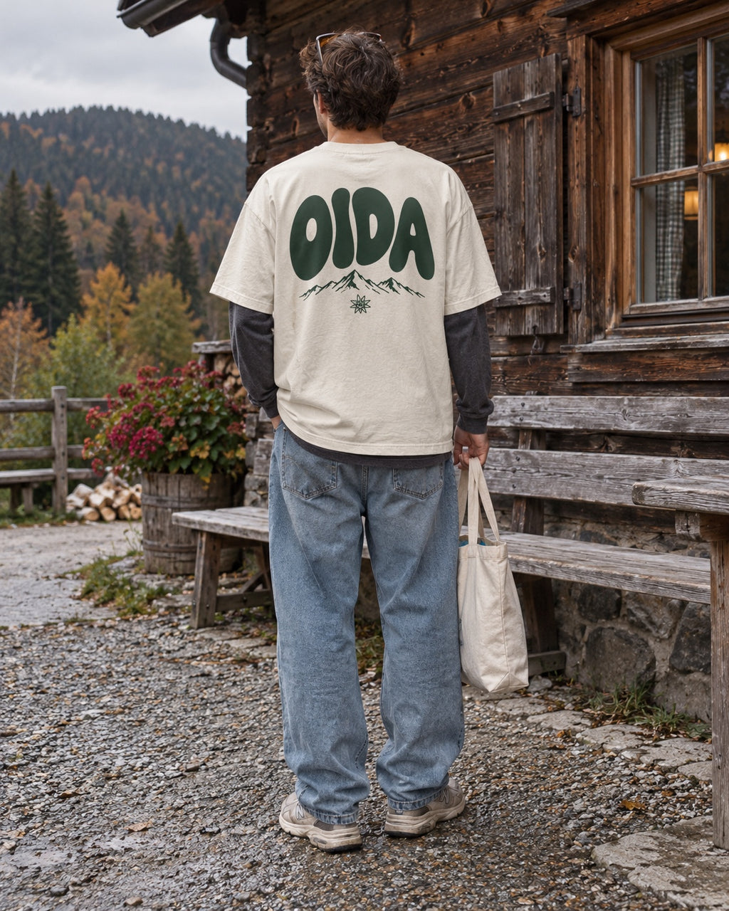 Herren Oversize-T-Shirt OIDA in Weiß – Rückenansicht vor einer Almhütte