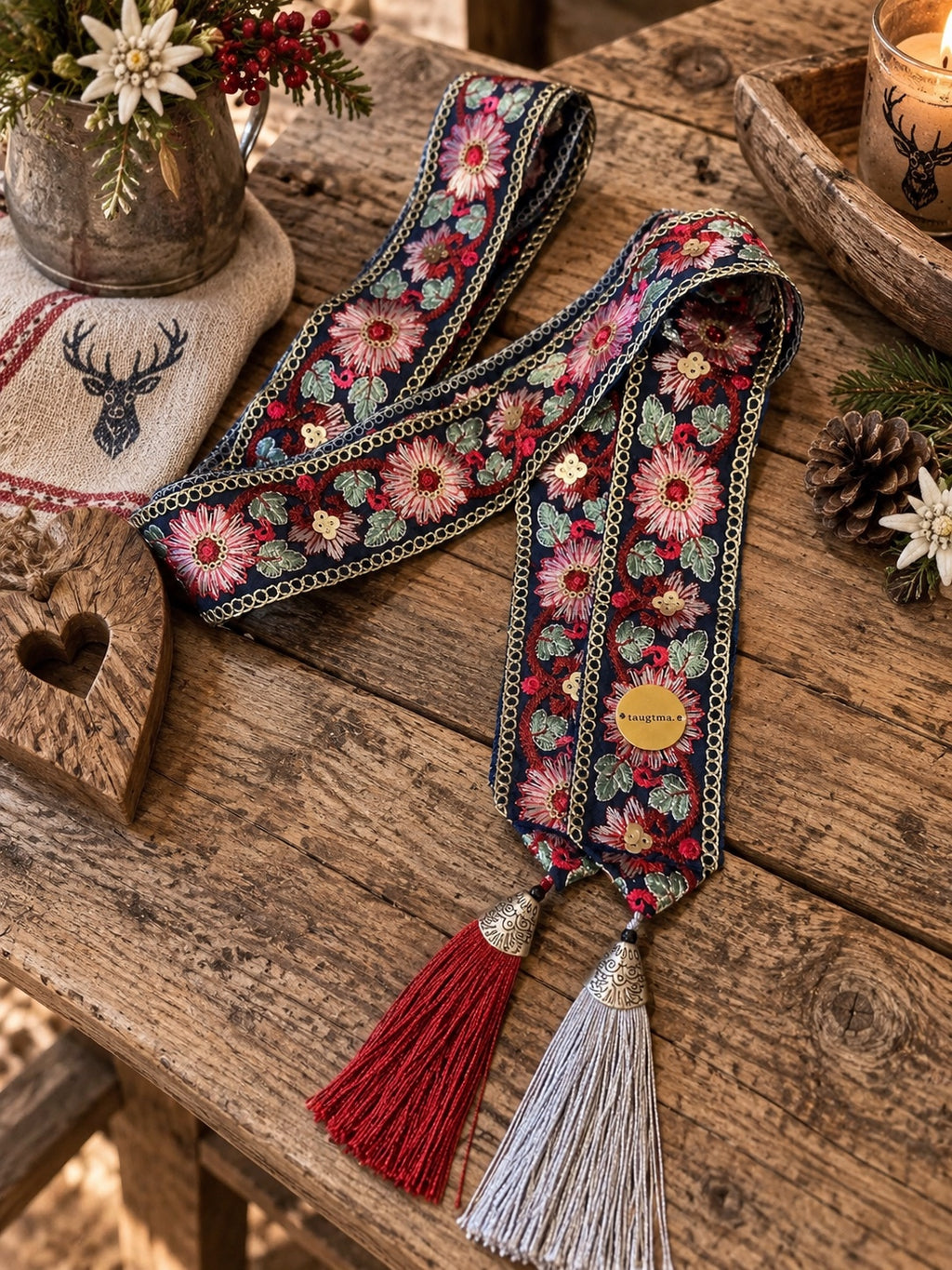 SCHMIGI Taillengürtel Navy mit buntem Blumenmuster und roten und hellgrauen Quasten auf einem Altholztisch