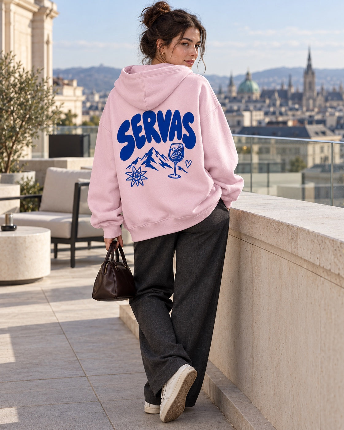 Damen Oversize-Hoodie SERVAS in Rosa am Model auf einer Dachterrasse