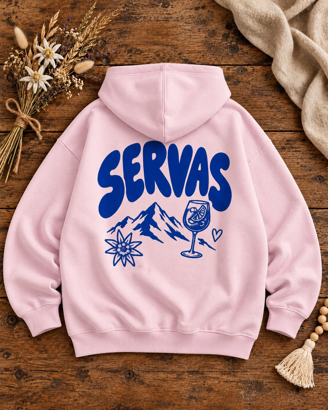 Damen Oversize-Hoodie SERVAS in Rosa mit blauem Rückenmotiv auf Altholztisch